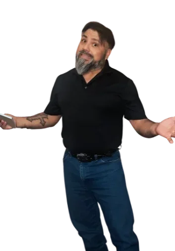 A man with a beard wearing a black shirt and blue jeans stands with a puzzled expression, holding a smartphone in one hand and shrugging his shoulders.